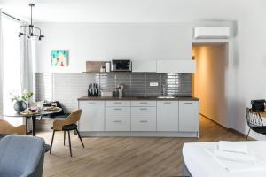 a kitchen with white cabinets and a table in a room at Apartments Dolac in Rijeka