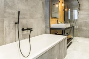 a bathroom with a bath tub and a sink at Apartments Dolac in Rijeka