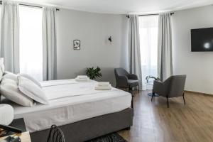 a bedroom with a large bed and two chairs at Apartments Dolac in Rijeka