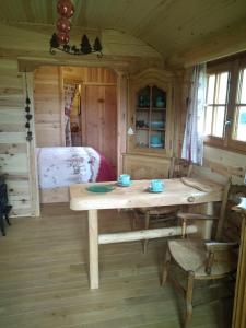 drewniany pokój ze stołem i łóżkiem w obiekcie Au Paradou du Bûcheron Adults only w mieście Lessive