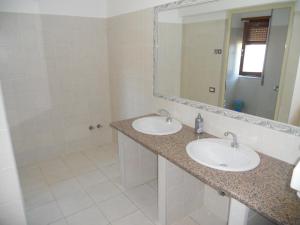 Baño con 2 lavabos y espejo en Hotel Mediterraneo, en Costa Paradiso
