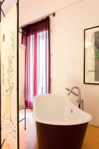 bañera grande en una habitación con ventana en Nuvole Residenza by Wonderful Italy, en Palermo