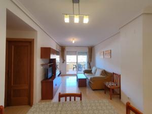 ein Wohnzimmer mit einer Couch und einem Tisch in der Unterkunft Costa Caribe II Nº 1028 in Oropesa del Mar