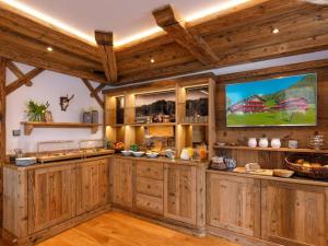 a kitchen with wooden cabinets and a flat screen tv at Steinberger Hof in Ruhpolding
