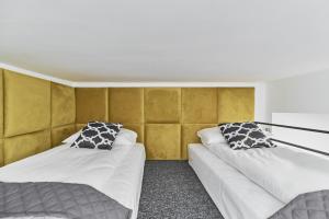 two beds in a room with yellow walls at Apartments Wrocław Ruska by Renters in Wrocław