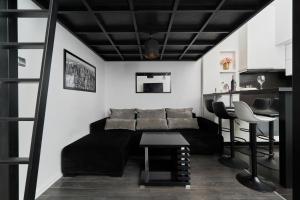 a living room with a black couch and a table at Apartments Wrocław Ruska by Renters in Wrocław