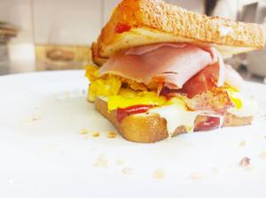 un sándwich con huevo de jamón y queso en un plato en Hotel Garisenda B&B - in Centro a Riccione -, en Riccione