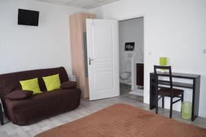 a living room with a brown couch and a table at Hôtel de La Croix de Malte in Cherbourg en Cotentin