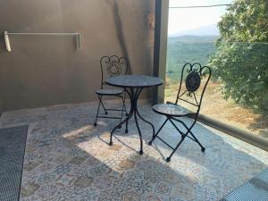 a table and two chairs in front of a window at King Crimson Luxury Apartments in Marathokefála