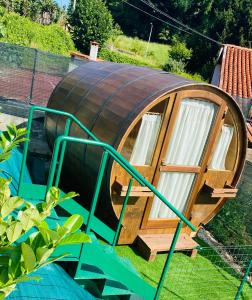 uma casa de hobbit de madeira redonda num jardim em VIVERONE LAKE ROOMS em Viverone