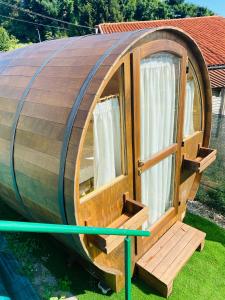 uma casa de hobbit de madeira redonda com uma janela em VIVERONE LAKE ROOMS em Viverone