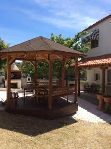 a wooden gazebo with a table and benches at Red House in Gerakini