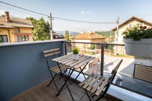 a wooden table and two chairs on a balcony at TheHouse - Apartment Kamenitza in Velingrad