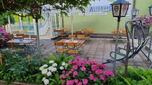 a garden area with tables, chairs and umbrellas at Hotel Auf d´ Steig in Lindau