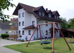 un columpio en un patio frente a una casa en Gästehaus Trostelhof, en Salem