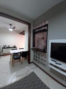 ein Wohnzimmer mit einem TV und einem Tisch mit Stühlen in der Unterkunft quarto melhor ponto de Cabo Frio in Cabo Frio