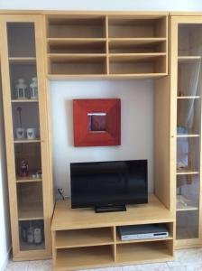 a tv in a book shelf with a tv at Red House in Gerakini
