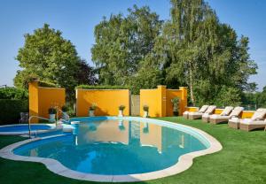 a swimming pool in a yard with lounge chairs at Bishopstrow Hotel and Spa - Small Luxury Hotels of the World in Warminster