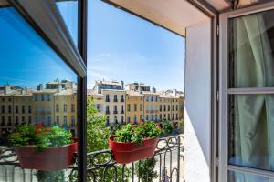 a balcony with two potted plants on a railing at Caf&eacute; de Paris in Aix-en-Provence