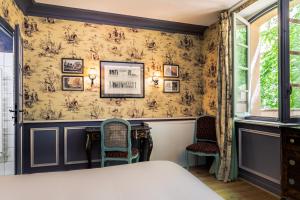een slaapkamer met een bed en 2 stoelen bij Café de Paris in Aix-en-Provence