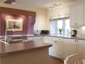a kitchen with a sink and a counter top at Stone Mouse Cottage in Harrop Fold