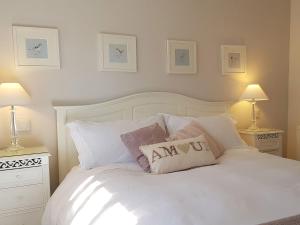 a bedroom with a white bed with pillows on it at Stone Mouse Cottage in Harrop Fold
