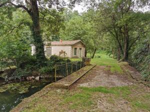 una casa vieja en el bosque al lado de un río en La Maison des mariés - Nature & Sèvre Niortaise, en Sciecq
