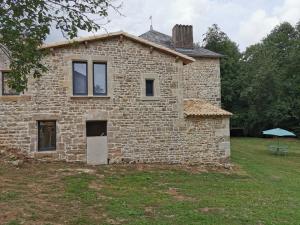 una antigua casa de piedra con un patio de césped en La Maison des mariés - Nature & Sèvre Niortaise, en Sciecq 7 fotos más