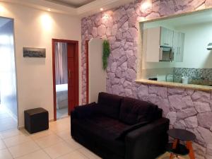 sala de estar con sofá y pared de piedra en New Apartment Copacabana, en Río de Janeiro