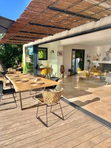 a patio with tables and chairs on a wooden deck at Découvrez la Villa « The View » in Cavalaire-sur-Mer