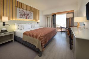 a hotel room with a bed and a balcony at Meliá Castelo Branco in Castelo Branco