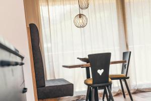 a table and two chairs in front of a window at Lichtung Woldererhof Auszeit in Racines