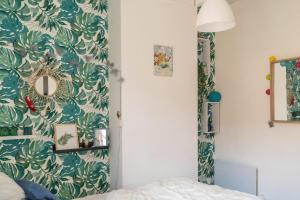 una camera da letto con carta da parati verde e bianca di Maison avec terrasse au coeur de Sancerre a Sancerre