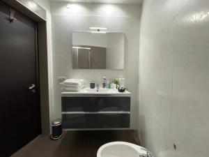 a bathroom with a sink and a toilet and a mirror at DMC Residence - Alloggi Turistici in Anzio