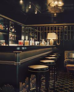 eine Bar mit einer Reihe von Hockern in einem Zimmer in der Unterkunft Château Voltaire in Paris