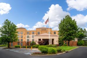 un edificio de oficinas con una bandera americana delante en Staybridge Suites Memphis-Poplar Ave East, an IHG Hotel, en Memphis