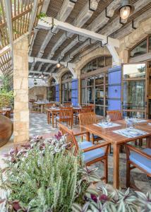 an outdoor patio with wooden tables and chairs at Columbia Beach Resort in Pissouri