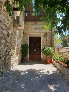 - un bâtiment avec une porte en bois et un balcon dans l'établissement La Casa di Antonio Rooms, à Palinuro