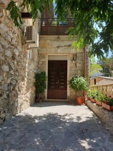 a building with a wooden door with a balcony at La Casa di Antonio Rooms and Apartments in Palinuro