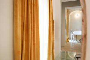 an orange curtain in a room with a table at BAYIT Charming Place in Polignano a Mare