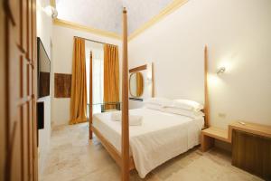 a bedroom with a bed and a mirror at BAYIT Charming Place in Polignano a Mare