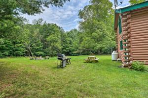 a backyard with a picnic table and a grill at Spacious Mtn Cabin on 7 Private Acres in Athol! in Athol
