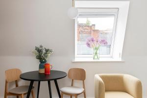 a table and chairs in a room with a window at Cove Minshull Street in Manchester