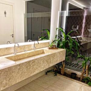 a bathroom with two sinks and a large mirror at Regis Hotel II in Registro