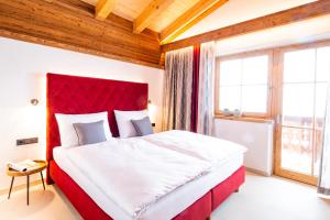 um quarto com uma cama grande e uma cabeceira vermelha em Ferienhaus Mandlberggut by globboard em Schladming
