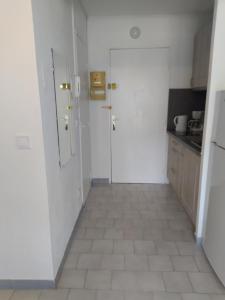 a kitchen with a white door and a tile floor at charmant studio à Balaruc les bains in Balaruc-les-Bains +4 photos