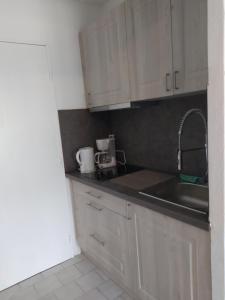 a kitchen with white cabinets and a sink at charmant studio à Balaruc les bains in Balaruc-les-Bains