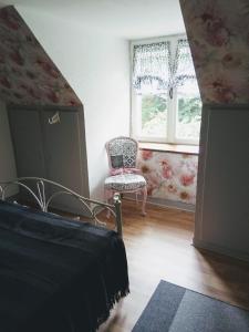 1 dormitorio con 1 cama, 1 silla y 1 ventana en Le Chalange, en Lapenty