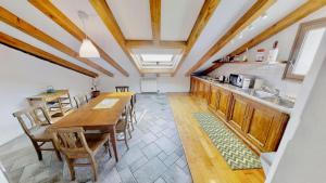 eine Küche mit einem langen Holztisch und Stühlen in der Unterkunft Appartamento San Michele in Triest