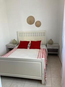 a bedroom with a white bed with red pillows at Family Tailor Made Flat in VSR in Porches